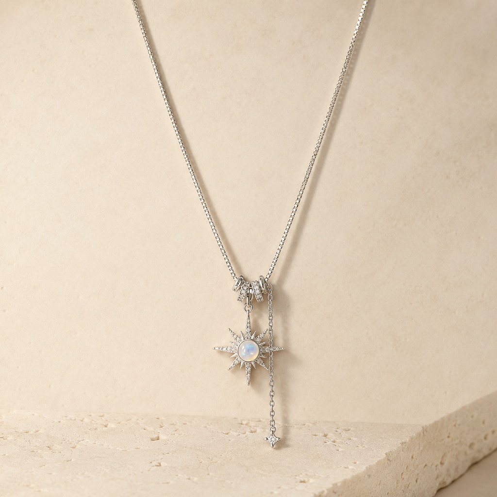 Polaris Star Drop Necklace on a warm ivory studio background