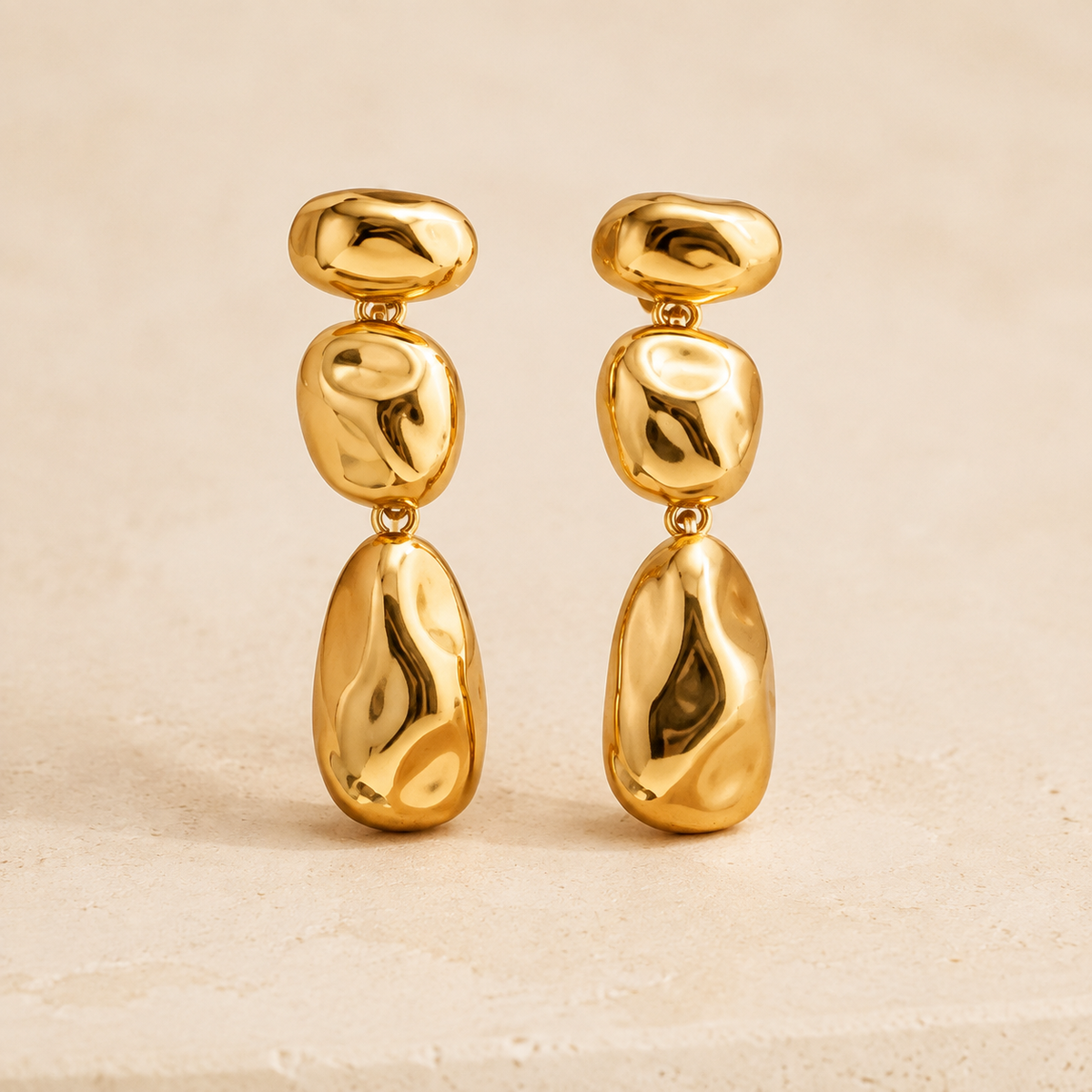 Aurelia Sculptural Drop Earrings on a warm ivory studio background