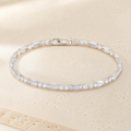 Rivière Crystal Tennis Bracelet on a warm ivory studio background