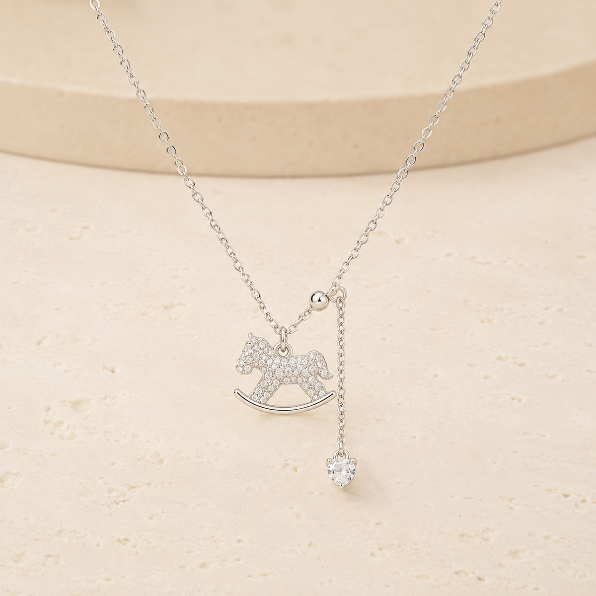 Lucky Rocking Horse Necklace on a warm ivory studio background